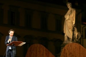 Benigni recitando con la escultura de Dante al fondo